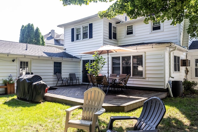 rear view of house with a wooden deck and a lawn