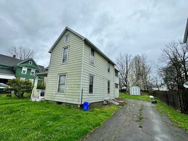 view of home's exterior with a storage shed and a lawn