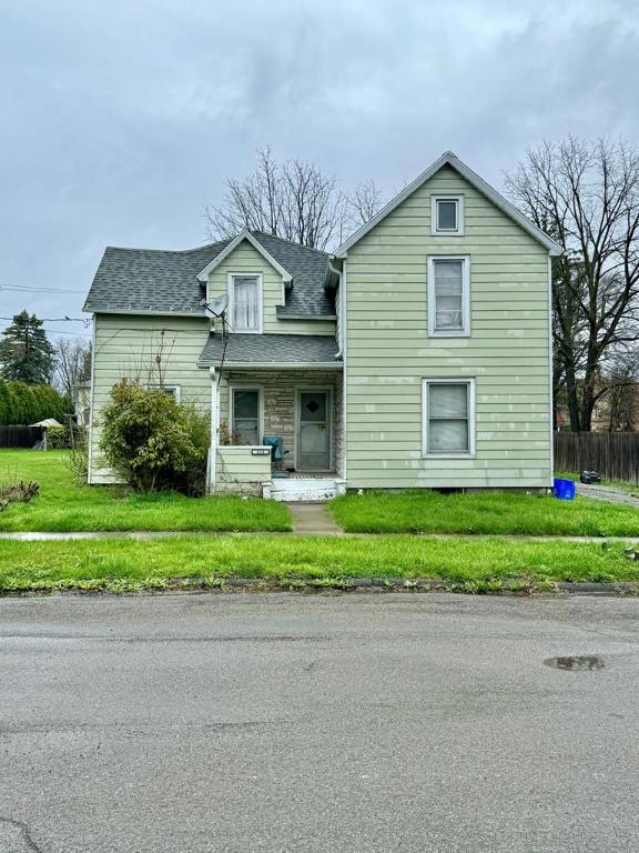 view of front of property featuring covered porch and a front lawn