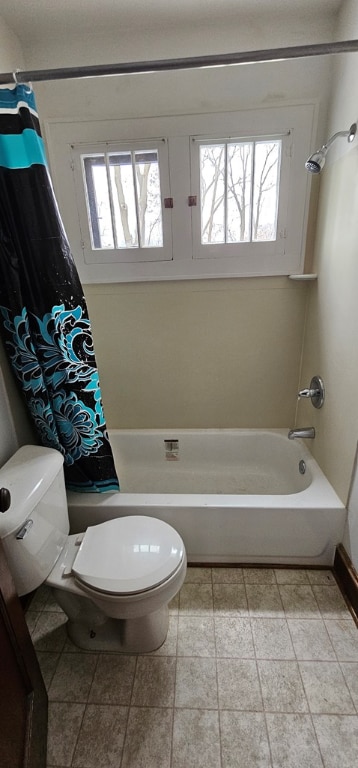 bathroom with a healthy amount of sunlight, shower / bathtub combination with curtain, and toilet