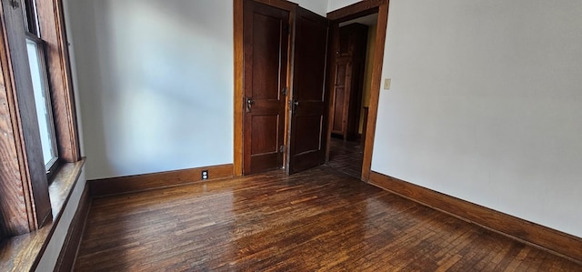 unfurnished room with dark wood-type flooring