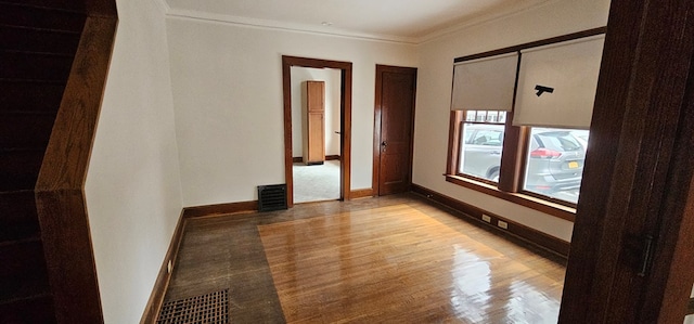 spare room with ornamental molding and light hardwood / wood-style flooring