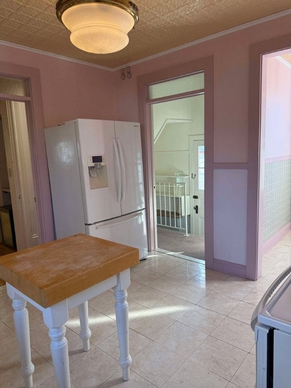 dining room featuring light tile patterned floors and ornamental molding