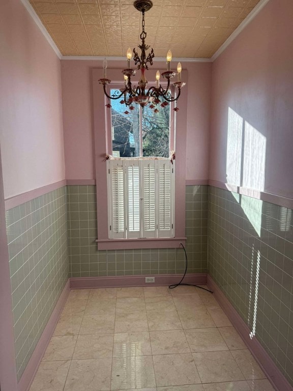 unfurnished dining area featuring an inviting chandelier, crown molding, and a healthy amount of sunlight