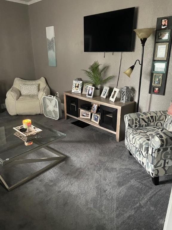 living room with crown molding and carpet floors