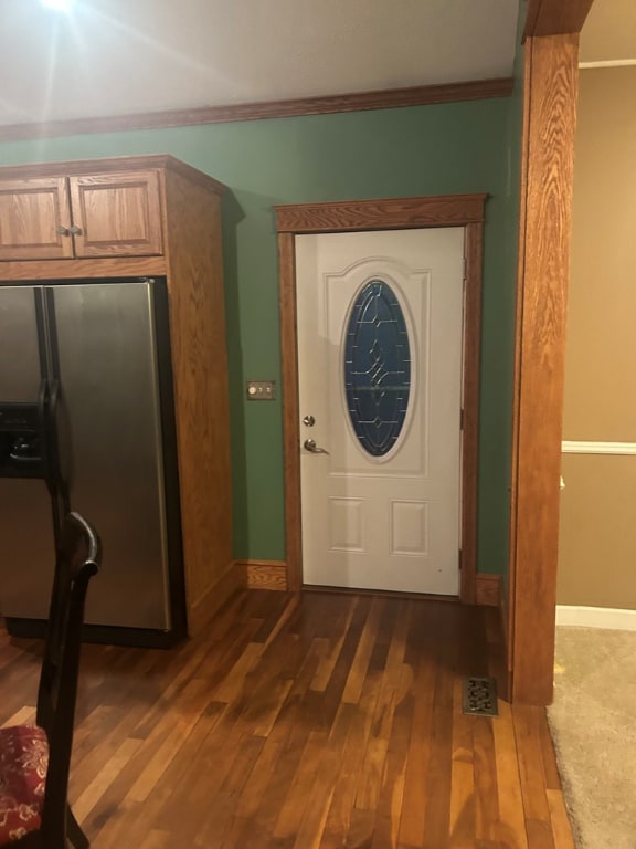 foyer entrance with crown molding and dark hardwood / wood-style flooring