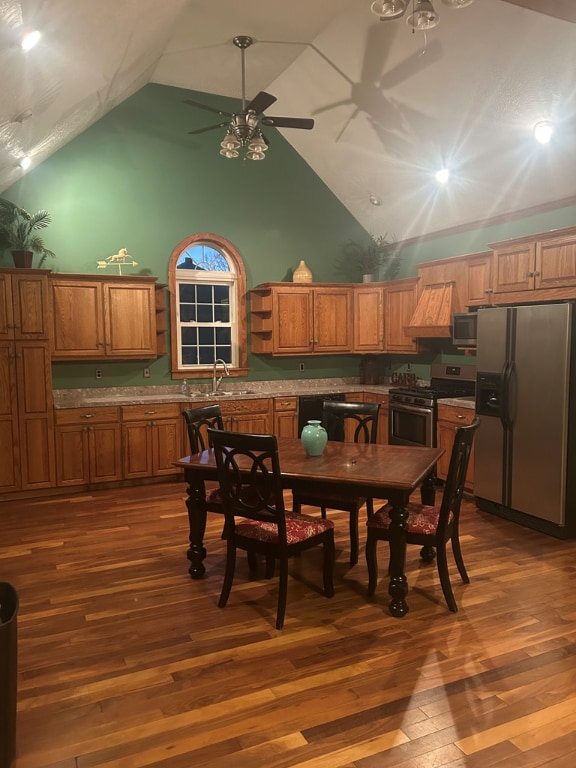 dining space featuring high vaulted ceiling, dark hardwood / wood-style floors, sink, and ceiling fan