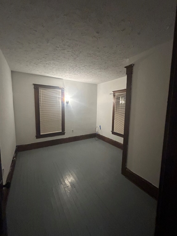 spare room featuring hardwood / wood-style flooring and a textured ceiling