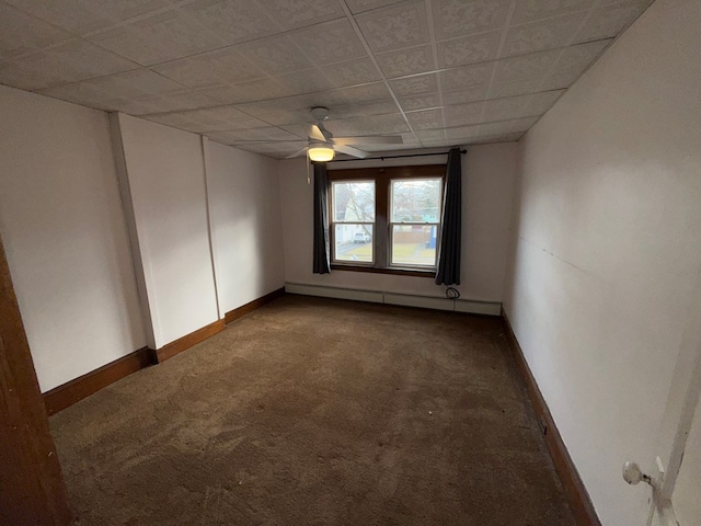 spare room featuring a baseboard heating unit, ceiling fan, and dark colored carpet