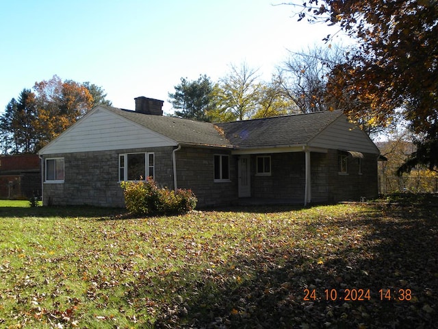 rear view of property featuring a lawn