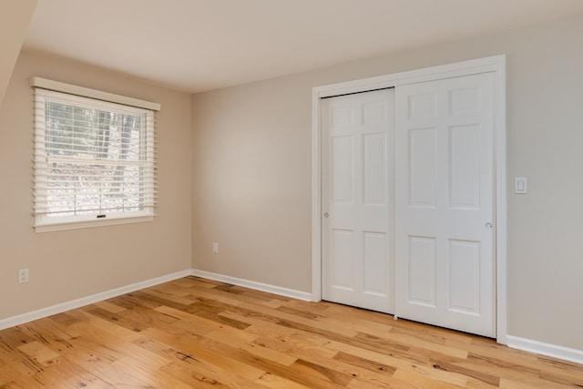 unfurnished bedroom featuring light hardwood / wood-style floors and a closet