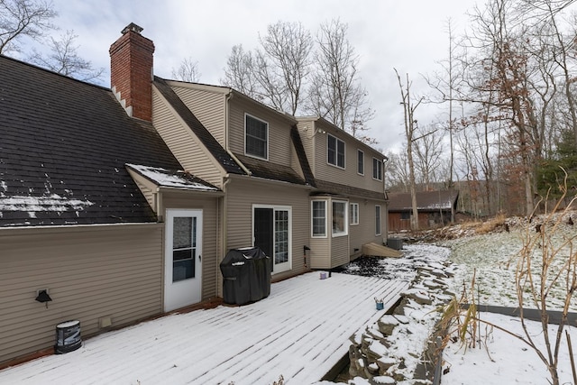 snow covered house featuring a wooden deck