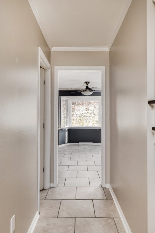 corridor featuring ornamental molding and light tile patterned floors