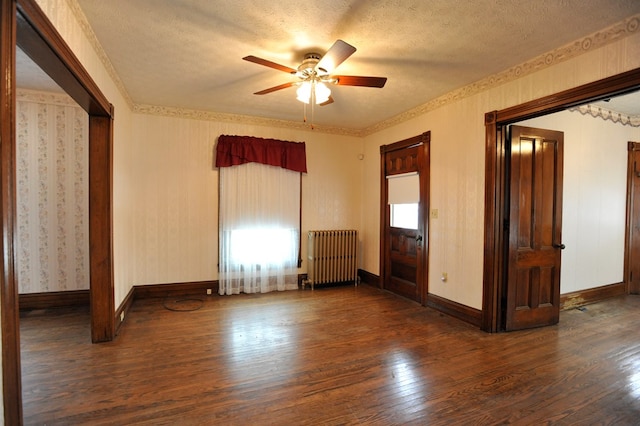 unfurnished room featuring dark wood-type flooring, ceiling fan, radiator heating unit, and a textured ceiling