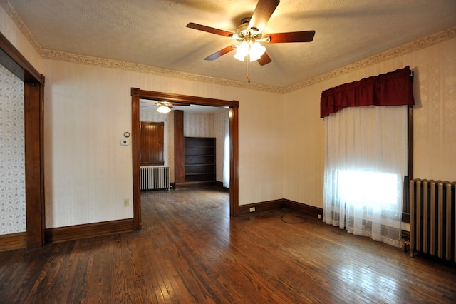 spare room featuring dark hardwood / wood-style flooring, radiator, and a textured ceiling