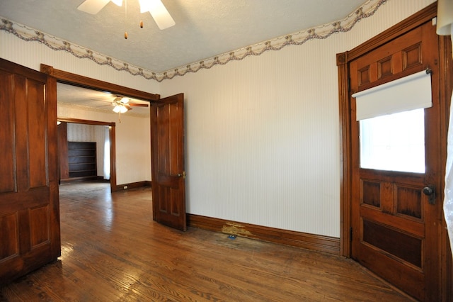 spare room featuring dark hardwood / wood-style floors, a textured ceiling, and ceiling fan