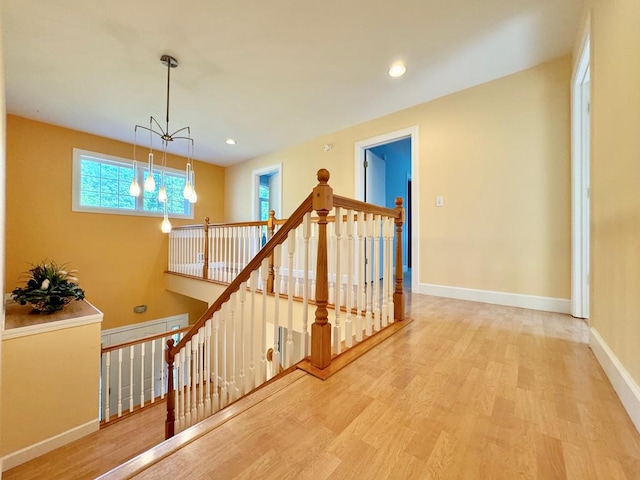 hallway featuring hardwood / wood-style flooring and an inviting chandelier