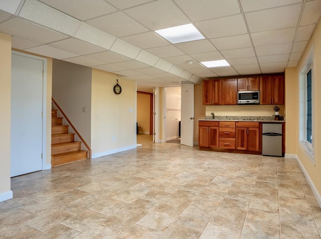 kitchen with sink, a drop ceiling, and refrigerator