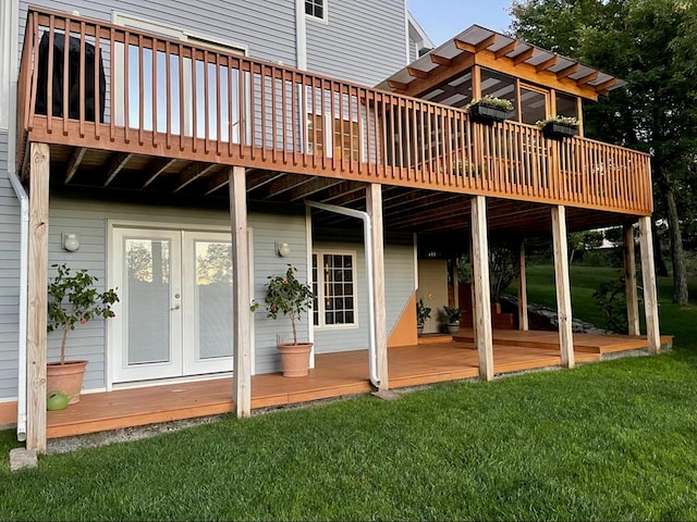 back of property with a yard, a deck, and french doors