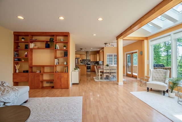 living room featuring light wood-type flooring and a skylight