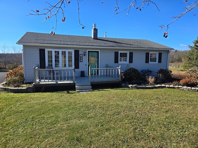 view of front of property with a deck and a front lawn