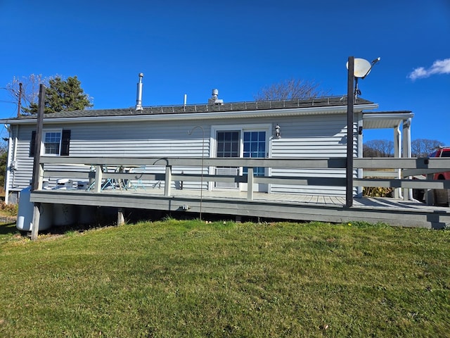 rear view of property featuring a yard and a deck