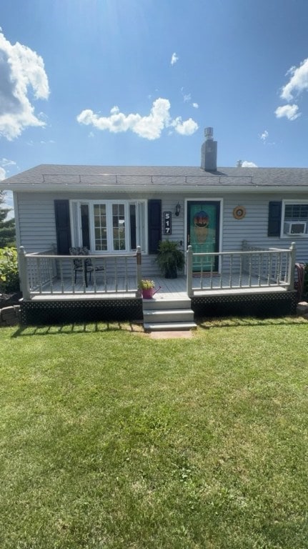 back of property featuring a wooden deck and a lawn