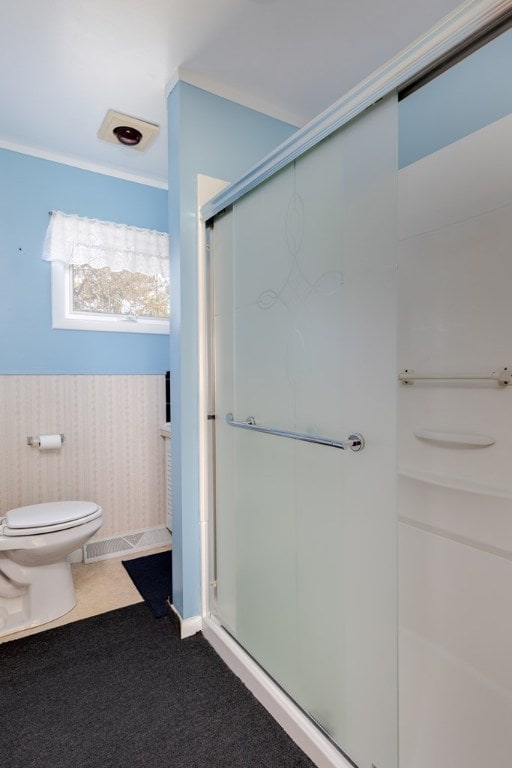 bathroom with toilet and a shower with shower door