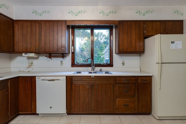 kitchen with white appliances, sink, and a textured ceiling