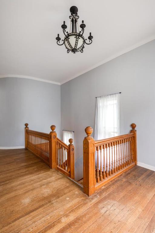 interior space with a notable chandelier, wood-type flooring, and ornamental molding