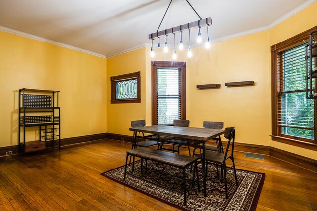 dining space with crown molding and dark wood-type flooring