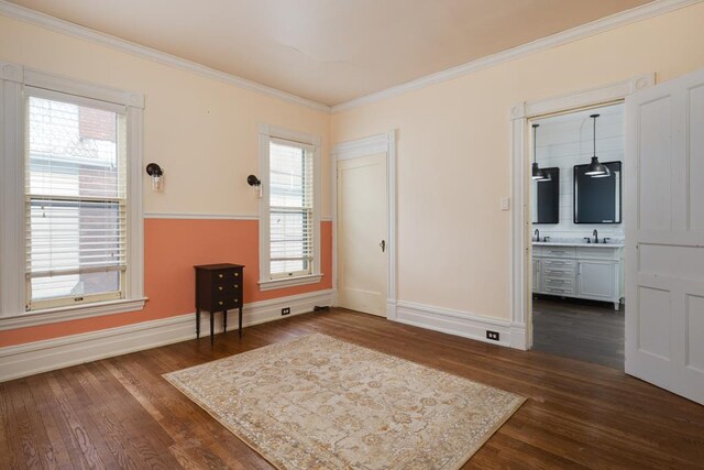 empty room with crown molding, dark hardwood / wood-style floors, and sink