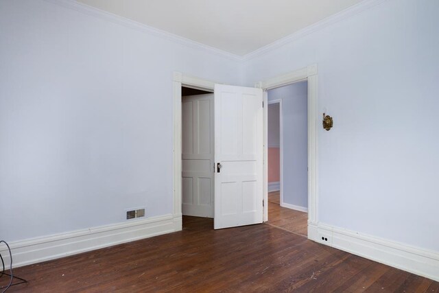 unfurnished bedroom featuring crown molding and dark hardwood / wood-style floors