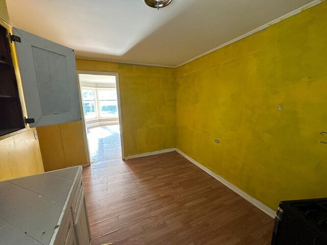 interior space with dark wood-type flooring and ornamental molding