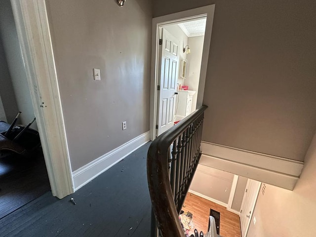 corridor with ornamental molding and hardwood / wood-style floors