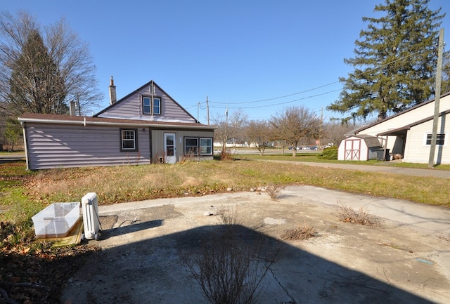 rear view of property with a storage unit