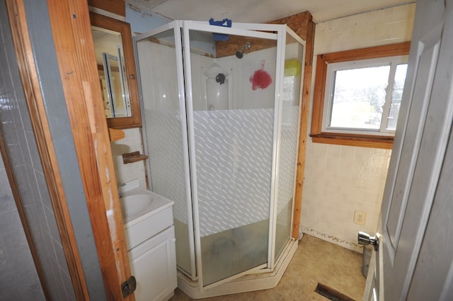 bathroom featuring vanity, tile walls, and walk in shower