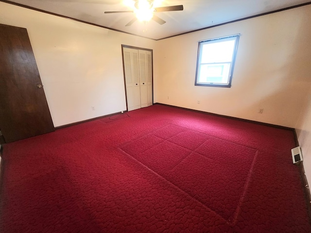 empty room with ornamental molding, carpet floors, and ceiling fan