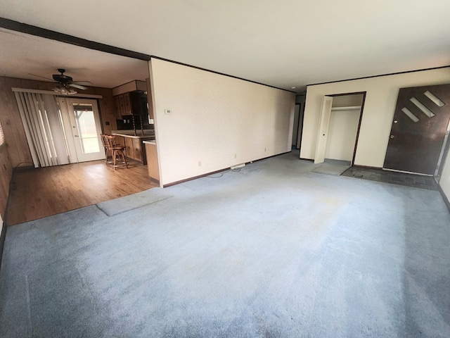 unfurnished living room featuring light carpet and ceiling fan