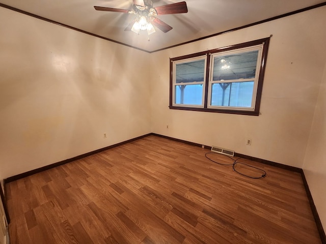 spare room featuring wood-type flooring, ornamental molding, and ceiling fan