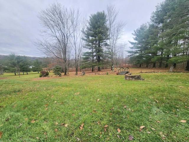 view of yard with an outdoor fire pit and a rural view