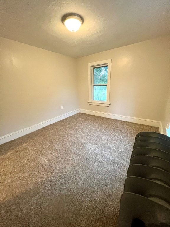 carpeted spare room featuring a textured ceiling