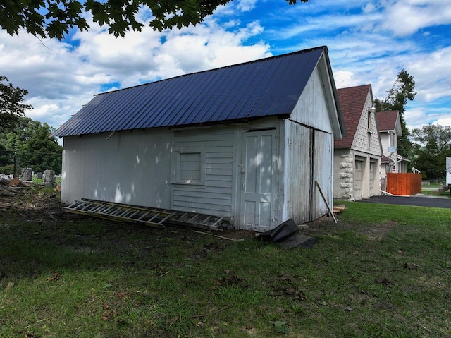 exterior space featuring a garage, a yard, and an outbuilding