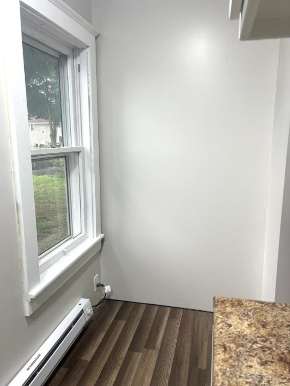 interior space with hardwood / wood-style flooring and a baseboard heating unit