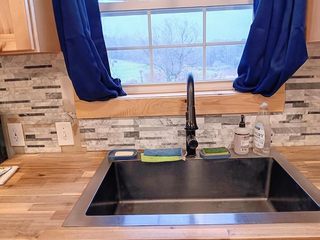 interior details featuring sink, wooden counters, and decorative backsplash