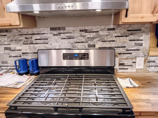 details featuring light brown cabinets, exhaust hood, wood counters, and stainless steel gas stove