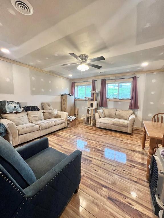 living room with light hardwood / wood-style flooring and ceiling fan