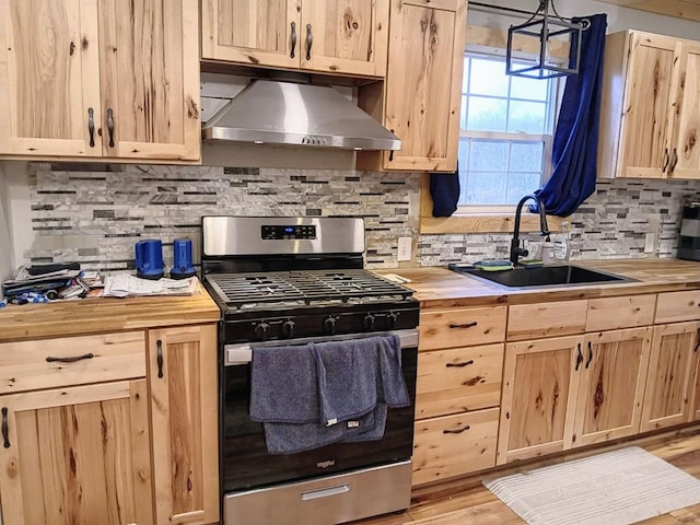 kitchen with pendant lighting, sink, wooden counters, stainless steel gas range oven, and light wood-type flooring