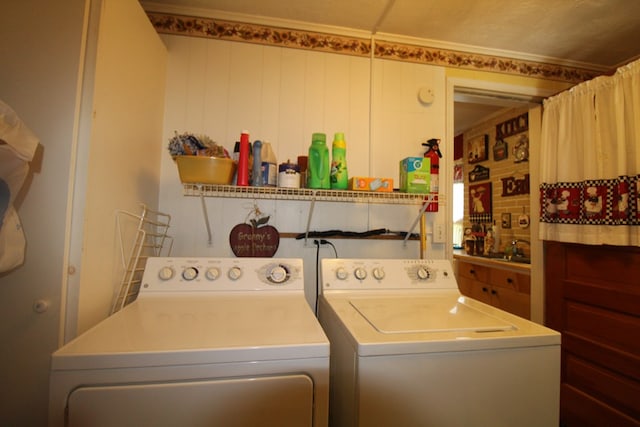 clothes washing area featuring sink and washer and dryer