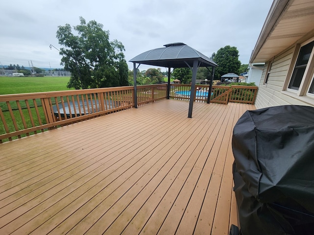 wooden terrace with a pool, a gazebo, and a grill